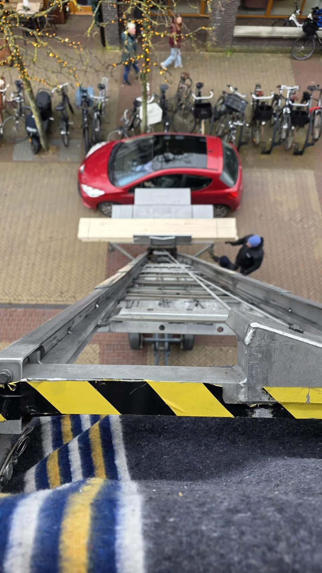 Bovenaanzicht van een ladderlift-platform met bouwmaterialen