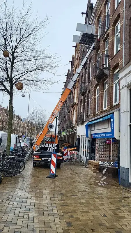 Ladderlift uitgeschoven naar een hoog gebouw in Amsterdam