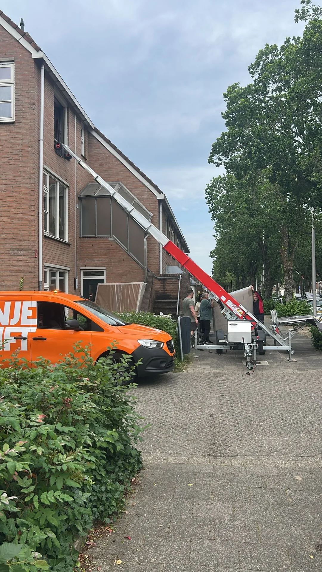 Verhuiswagen van Verhuislifthuren.nl in een woonwijk, klaar voor inzet met verhuislift